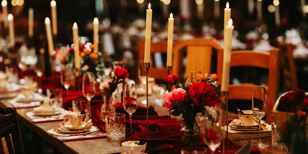 Romantic wedding reception tablescape with candlelight, red floral arrangements and elegant styling by Wonderland Blooms in Yorkshire